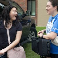 New arrival chatting with volunteer as they unload car